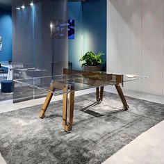 a glass dining table with wooden legs in a modern office setting on carpeted flooring