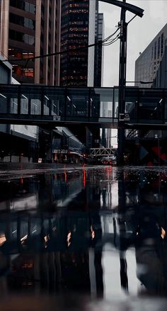 the reflection of buildings in the water is seen on the surface of the wet ground