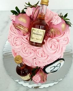 a cake decorated with roses and bottles of liquor