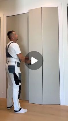 a man is standing in front of some closets and looking at the wall with his back to the camera