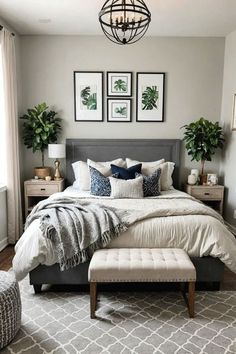 a bedroom with gray walls, white bedding and pictures on the wall above it