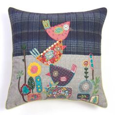 a decorative pillow with birds and flowers on it