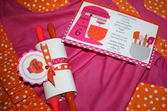 a pink and orange table cloth with some utensils on it