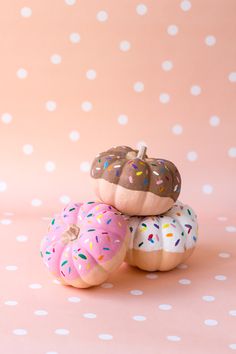 three donuts with sprinkles on them are sitting next to each other