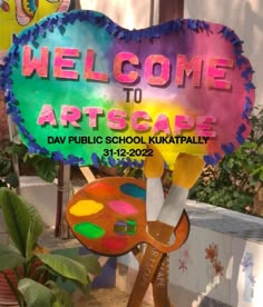 the welcome sign to artscapee is painted in bright colors and stands next to a potted plant