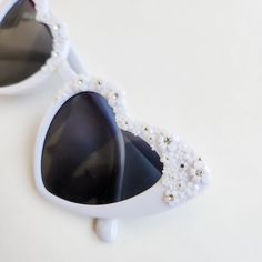 Look stunning on your wedding day in these amazing floral heart shaped sunglasses. These glasses are perfect for the person that loves white, rhinestones and pearls to wear at a garden party, bachelorette party wedding or bridal shower. These will look stunning in engagement photos or wedding photos. Not getting married? These are perfect to complete your music festival or concert look. Pair with your favorite summer dress. Each pair is hand embellished with the cutest miniature flowers and the Elegant Heart-shaped Sunglasses With Tinted Lenses, Elegant Heart-shaped Tinted Sunglasses, Elegant Summer Wedding Sunglasses, Elegant Heart-shaped Party Sunglasses, Heart-shaped Sunglasses For Summer Weddings, Heart-shaped Wedding Sunglasses For Summer, Elegant White Sunglasses For Wedding, Elegant White Wedding Sunglasses, White Sunglasses For Spring Gift