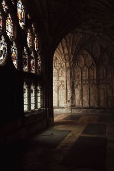 an old cathedral with stained glass windows and stone flooring in the middle of it