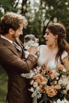 a bride and groom are holding a stuffed animal in their hands as they look at each other