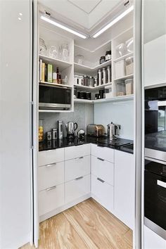 a kitchen with white cupboards and black counter tops on the wall, along with stainless steel appliances