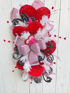 a red and white heart wreath hanging on a wall