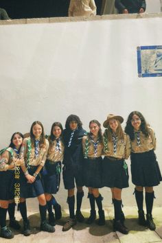 a group of young women standing next to each other in front of a white wall