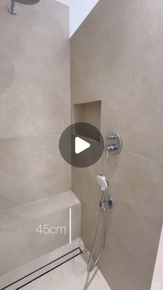 a walk in shower sitting next to a tiled wall and ceiling mounted faucet