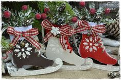 three christmas stocking ornaments sitting next to each other on a table with pine cones