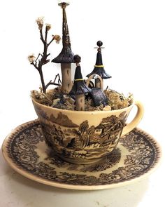 a teacup filled with figurines sitting on top of a saucer