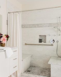 a white bathroom with a shower, sink and bathtub is featured on instagram