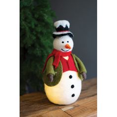 a small snowman sitting on top of a wooden table