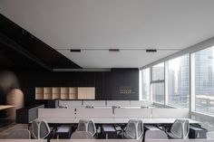 an empty conference room with chairs and desks in front of large windows overlooking the city