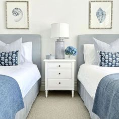 two beds with blue and white bedding in a bedroom