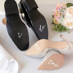 two pairs of shoes sitting on top of a table next to a bouquet of flowers