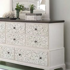 a white dresser with drawers and a mirror