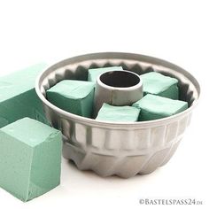 a cake pan filled with green sugar cubes next to a block of pinkish