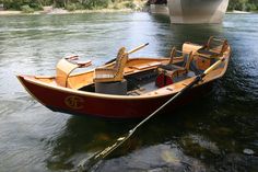 a small wooden boat in the water near a bridge