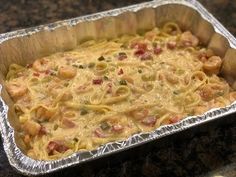 a casserole dish with pasta and vegetables in it on a counter top, ready to be eaten