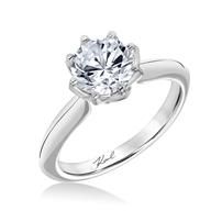 a white gold engagement ring with an oval cut diamond in the center and inscription on the side