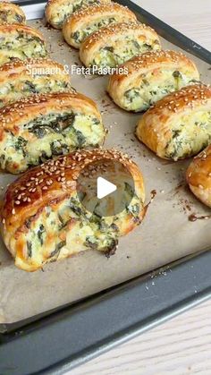 baked bagels with cheese and spinach on a baking sheet