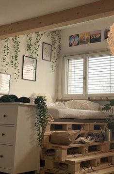 a living room filled with furniture and lots of greenery on the wall next to a bed