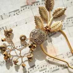 This stunning antique gold-plated hairpin is a one-of-a-kind piece, featuring vintage leaves with intricate detailing and a unique medieval-inspired coin button. Each pin has a different coin, collected during a special component hunt, making every piece truly unique.  The design is elevated with earthy bronze and gold Czech lampwork glass beads, Austrian crystals, and vintage metal discs.  Perfect for adding a touch of timeless elegance to any look. A must-have accessory for those who love vintage-inspired, exclusive designs! Style P005 - Golden Relic Pin Jewel is bedazzling mannequin's updo on the left side. This listing is for one pin.  This item is meticulously handcrafted in our studio located in the USA. Materials: - antique gold-plated brass leaf  - antique gold-plated coin button - Wedding Clip Art, Autumn Bridal, Vintage Leaves, Hairpin Accessories, Wedding Clip, Vintage Autumn, Artistic Wire, Wedding Clipart, Bridal Headpiece