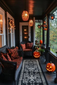 a porch decorated for halloween with pumpkins and lights