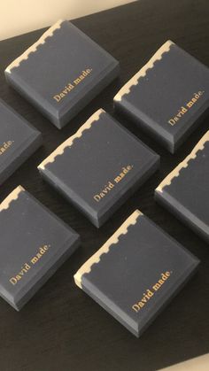 six different types of chocolates are arranged on a black table with gold trimming