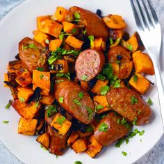 a white plate topped with sausage and sweet potato hashbrowns next to a fork