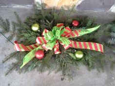 a green and red christmas wreath with ornaments