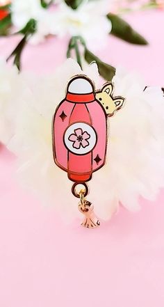 a pink phone charm with a giraffe on it's back and flowers in the background