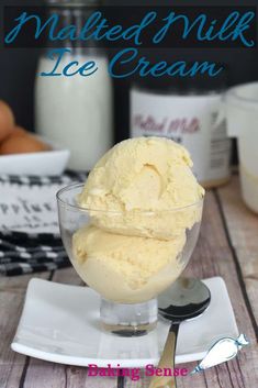 homemade ice cream in a glass bowl on a white plate with spoons next to it