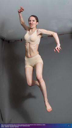 a woman jumping in the air with her legs spread