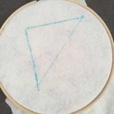 a close up of a white cloth with a blue triangle on it