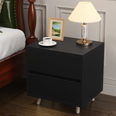 a night stand with a cup and saucer on it next to a nightstand table