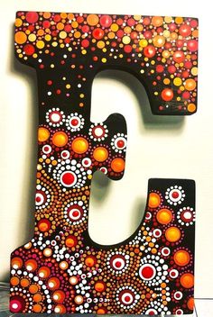 the letter c is painted with dots and circles on black, red, orange and white