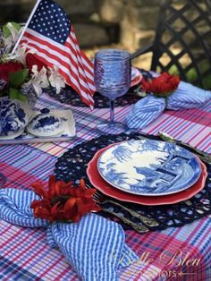 the table is set with blue and white plates, red napkins, and an american flag