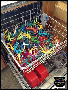 a dishwasher filled with lots of different colored scissors in it's tray