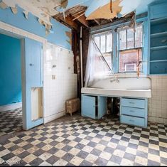 an old run down bathroom with blue and white tiles on the floor, walls and ceiling