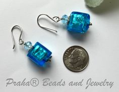 Perfect for any occasion. Simple, bright blue Murano glass square cubes drop from sterling silver ear wires. Swarovski crystals and rondells sit atop the beads. Silver foil is added inside the bright blue translucent glass beads. The beads measure 12MM. All sterling silver components. The length of the earring are just over 1 1/4" from the top of the handcrafted sterling silver ear wires. Nickel-free Rectangular Czech Glass Jewelry, Blue Earrings With Spacer Beads For Gift, Blue Square Sterling Silver Jewelry, Blue Hypoallergenic Glass Jewelry, Hypoallergenic Blue Glass Jewelry, Blue Beaded Rectangular Jewelry, Blue Rectangular Beaded Jewelry, Nickel Free Blue Rectangular Jewelry, Adjustable Blue Square Pendant Jewelry