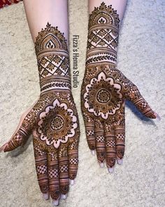 two hands with henna designs on them, one is showing the intricate design and the other has an elaborate pattern