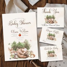 three baby shower cards on top of a bed next to an envelope and napkins