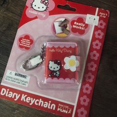 a hello kitty keychain is in its package on the table with it's tag