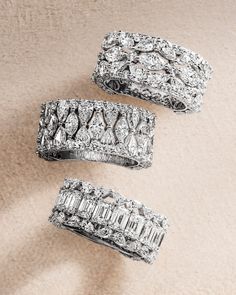 three diamond rings sitting on top of a carpeted floor next to each other,