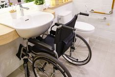 a bathroom with a sink, toilet and wheelchair